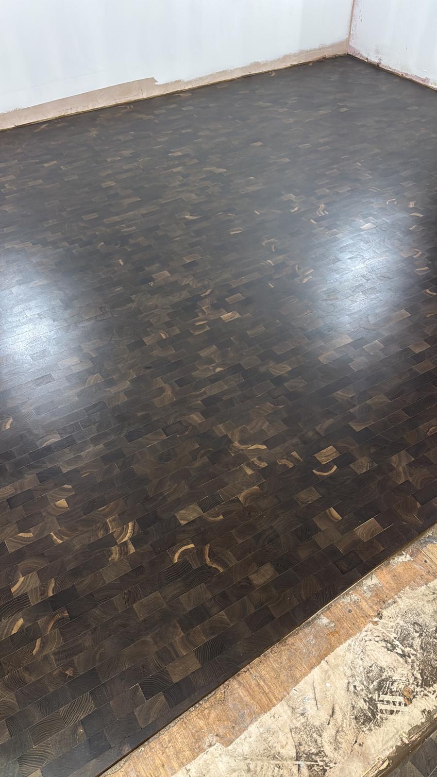Dark-stained end-grain timber block flooring with a distinctive geometric grain pattern and rich textured finish.