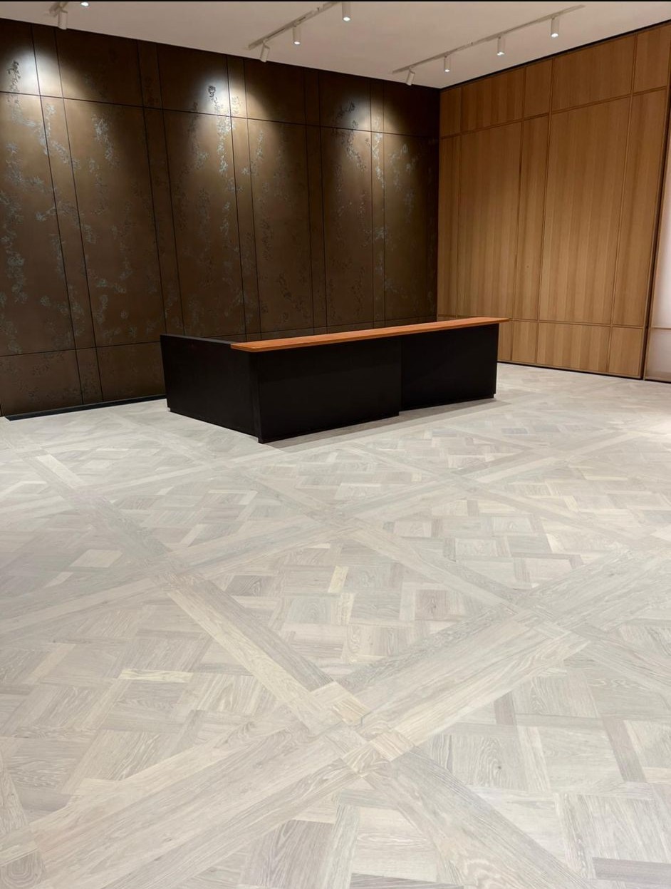 Light geometric parquet floor with intersecting timber patterns in a contemporary interior.
